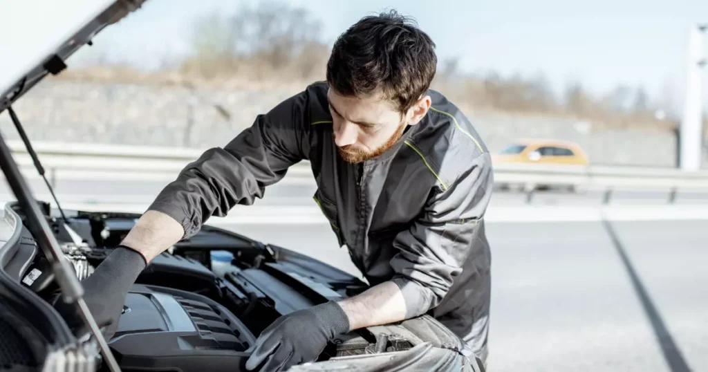 A person looking at the hood of a car