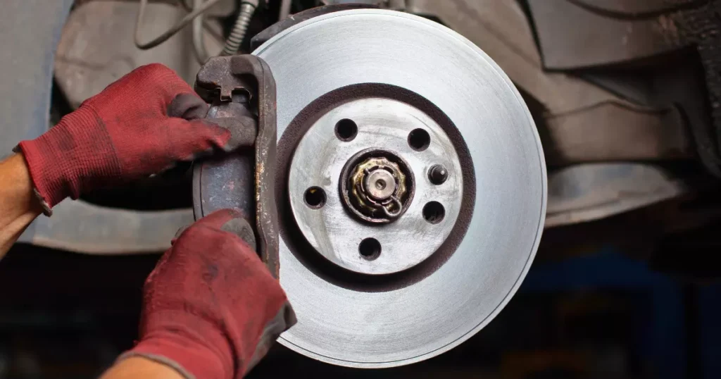 A hand holding a brake disc 